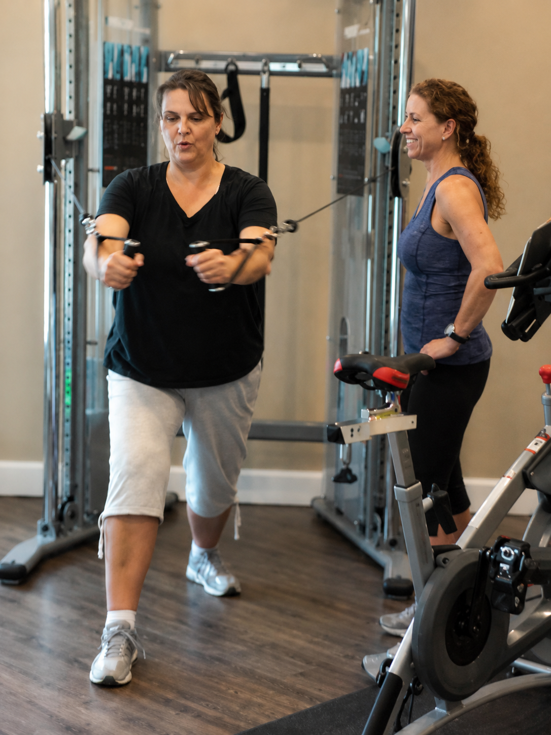 Gloria and Camille training on cable machine